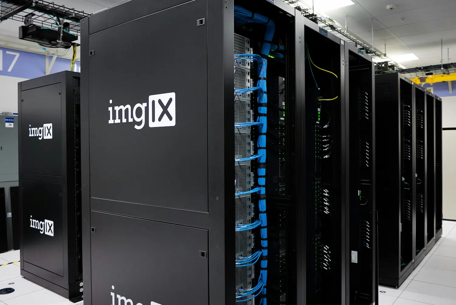En rekke serverrack med synlige kabler og utstyr i et moderne datasenter.